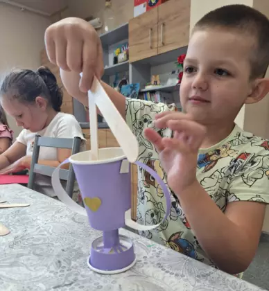 Chłopczyk i dziewczynka wykonują prezent na Dzień Taty.