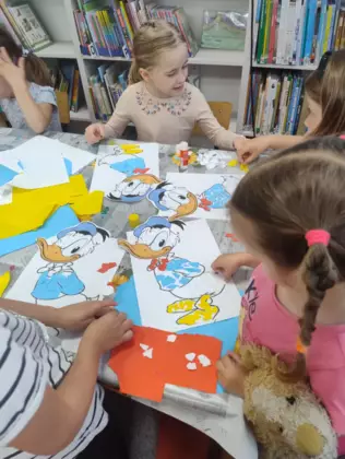 Dzieci wyklejają postać kaczora Donalda.