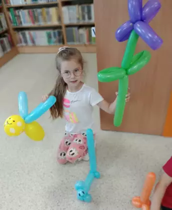 Dziewczynka pozująca ze swoimi pracami.