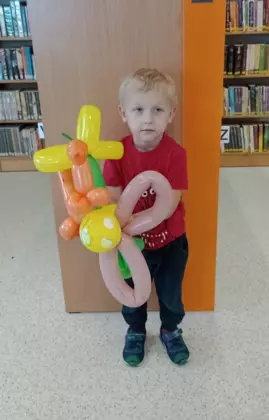 Chłopczyk trzymający swoje balonikowe prace.