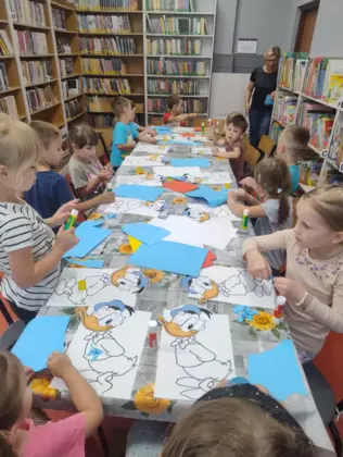 Dzieci wyklejają postać kaczora Donalda.