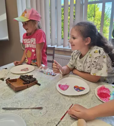 Dziewczynki malują serduszka dla mamy.