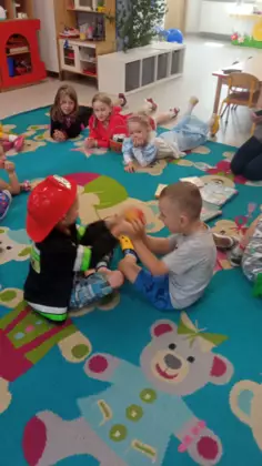 Zabawy przedszkolaków na dywanie.