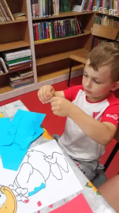 Chłopczyk wykleja kaczora Donalda.