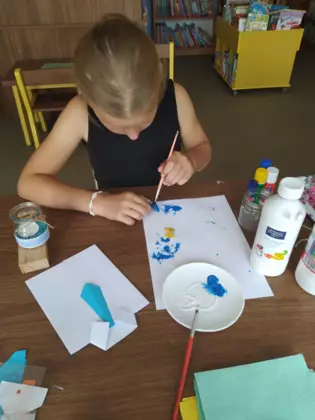 Dziewczynka maluje obrazek dla taty.