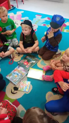 Zabawy przedszkolaków na dywanie.