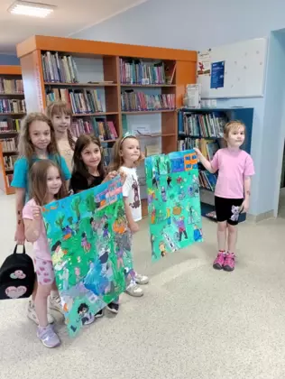 Zdjęcie grupowe uczestników zajęć z ich wspólną pracą plastyczną.