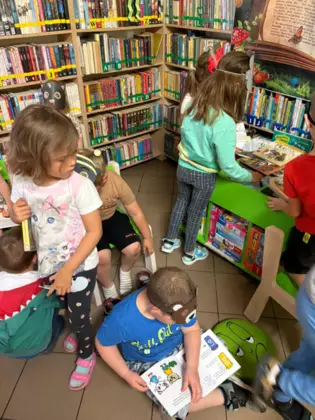 Przedszkolaki oglądają książeczki.