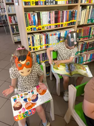 Przedszkolaki oglądają książeczki.