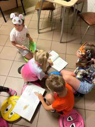 Przedszkolaki oglądają książeczki.