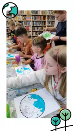 Dzieci malują ziemię kolorowymi farbami.