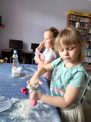 Dwie dziewczynki wsypują mąkę do balona.