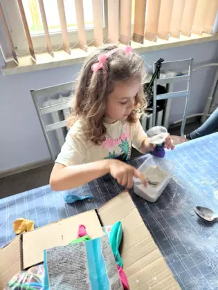 Dziewczynka wsypuje mąkę przez lejek do balona.