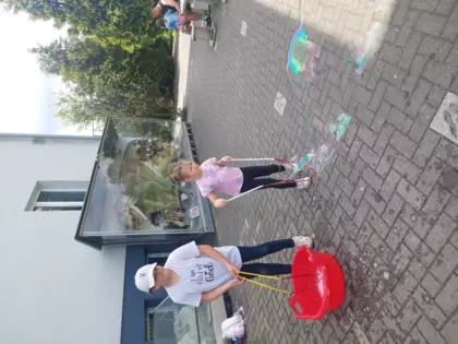 Dzieci puszczają duże bańki.