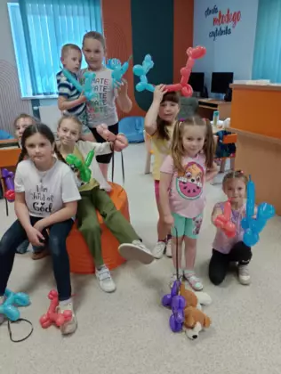 Zdjecie grupowe dzieci. trzymają balonowe pieski.