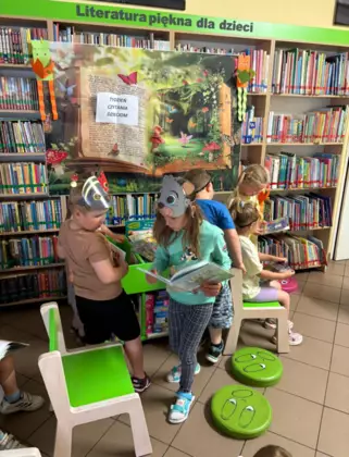 Przedszkolaki oglądają książeczki.