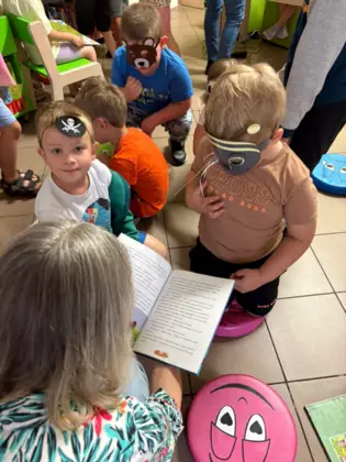 Przedszkolaki oglądają książeczki.