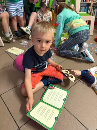 Przedszkolaki oglądają książeczki.