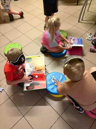 Przedszkolaki oglądają książeczki.