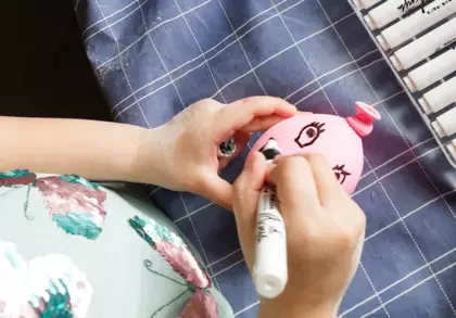 Dziewczynka dekoruje swojego gniotka.