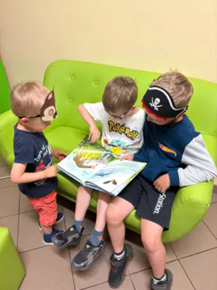 Przedszkolaki oglądają książeczki.