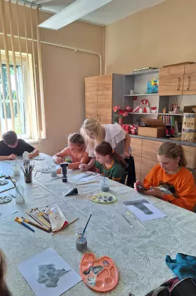 Dzieci malują farbami obraz.