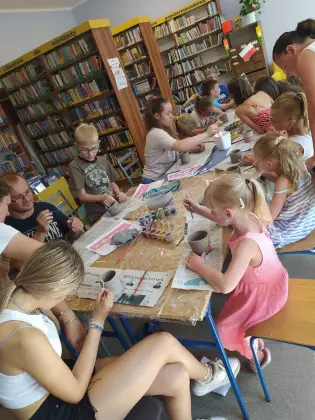 Dzieci tworzą swoje kubki z gliny.