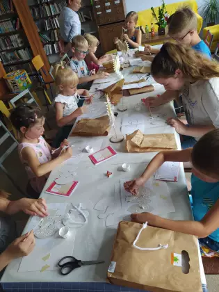 Dzieci wykonują statuetkę Orła Białego z osikowych wiórków.