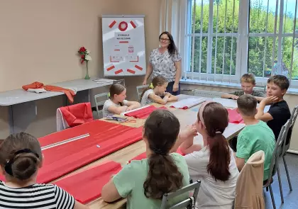 Uczestnicy spotkania słuchają prelekcji na temat symboli narodowych.