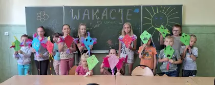 Dzieci pozują do wspólnego zdjęcia trzymając latawce w rękach.