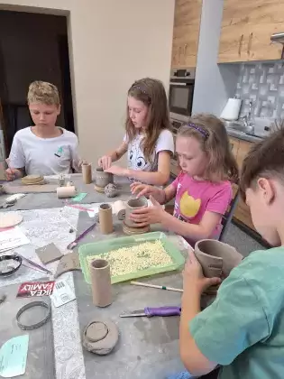 Dzieci na zajęciach ceramicznych wykonują kubek patriotyczny.