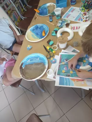 Dzieci wykonują wakacyjne obrazki.