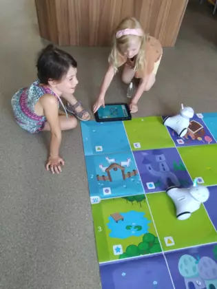 Dwie dziewczynki wspólnie programują Photona za pomocą tabletu.