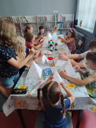 Dzieci malują styropianowe góry farbami .