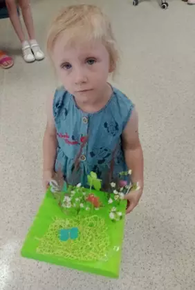 Dziewczynka prezentuje swoją kwiecistą łąke.