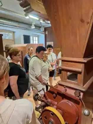 Uczestnicy wycieczki oglądają maszyny w młynie.