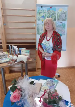 Maria Dziuk stoi przy stoliku i opowiada legendy o Wiśle.