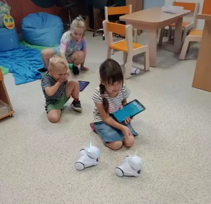 Dzieci bawią się robotami Photon.