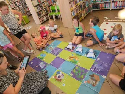 Dzieci wraz z instruktorką siedzą na podłodze i programują Photona.