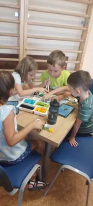 Dzieci składają pojazdy z klocków lego.