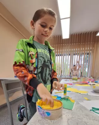 Chłopczyk wykleja w środku swój koszyczek wakacyjny.