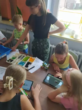 Uczestnicy składają pojazdy z klocków lego.