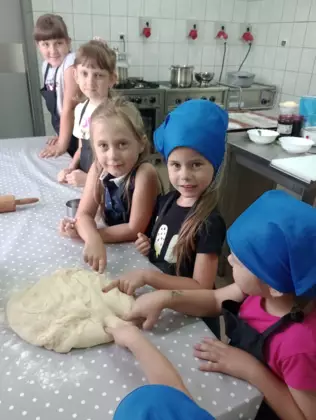 Dzieci sprawdzają czy ciasto na buchty jest już gotowe.