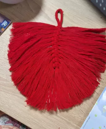 Czerwony listek wykonany z makramy.