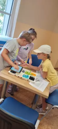 Dzieci budują pojazdy z klocków lego.