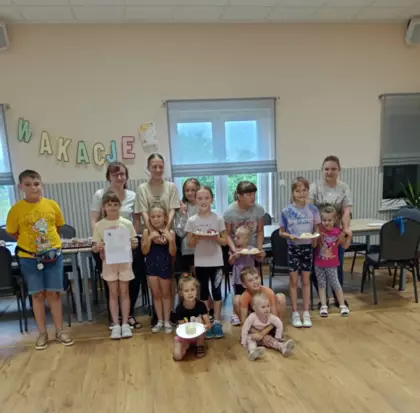 Grupowe zdjęcie uczestników zajęć z ugotowanymi kluskami na parze.