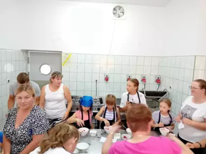 Dzieci dekorują swoje desery (szpajzy) świeżymi owocami.