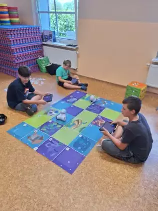 Trzech chłopaków na tablecie programuje jazdę Photonem.