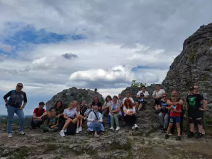 Uczestnicy wycieczki siedzą na skałkach na górze Zborów.