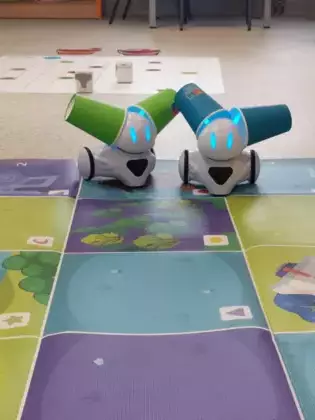 Dwa Photony z kolorowymi kubeczkami na czułkach.